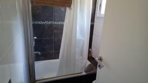 a bathroom with a tub and a shower curtain at Okin 22 La Reserva in Costa del Este +1 photo
