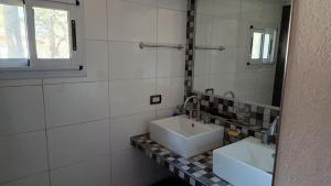 a bathroom with two sinks and a mirror at Okin 22 La Reserva in Costa del Este
