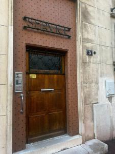 une porte menant à un bâtiment en briques avec un panneau au-dessus de celui-ci dans l'établissement Zola Saint Ouen, à Saint-Ouen