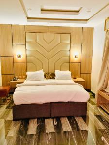 a bedroom with a large bed with a wooden headboard at MrSmith Hotel in Awka