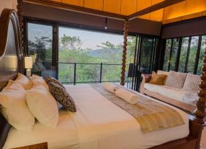 a bedroom with a large bed with a large window at The Cassowary - Luxury Rainforest Retreat in Cassowary +87 photos