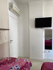 Μια τηλεόραση ή/και κέντρο ψυχαγωγίας στο Suíte 1 com cama de casal,em apartamento compartilhado ar condicionado, tv, e Wi-fi -frigobar