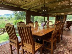 a dining room with a wooden table and chairs at Willow Weir River Cottage in Dullstroom