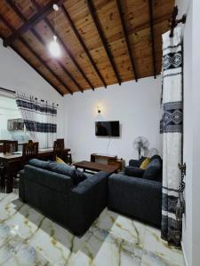 een woonkamer met 2 banken en een televisie bij Victoria Heritage Inn - 2BR Fully Furnished Apartment in Digana