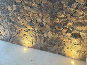 クタにあるZENARA lombokの部屋の照明が付いた石の壁