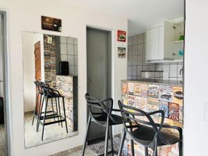 a kitchen with black chairs and a counter at Enseada Azul Home in Guarapari