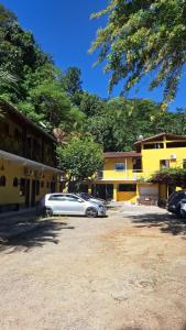 una macchina bianca parcheggiata di fronte a un edificio di Pousada Três Irmãos a Parati