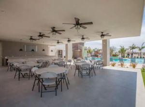 a banquet hall with tables and chairs and a pool at Casa de Las Olas in La Paz