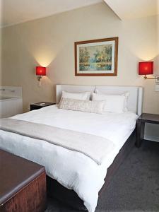 1 cama blanca grande en una habitación con 2 lámparas en Cape Town CBD Pool Near CTICC Parliament Waterfront, en Ciudad del Cabo