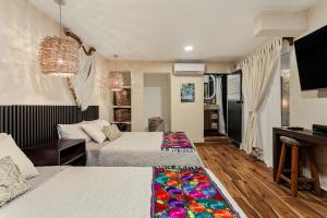 een hotelkamer met 2 bedden en een piano bij Villa Lol Tun Breakfast and Beach Club Included in Isla Mujeres