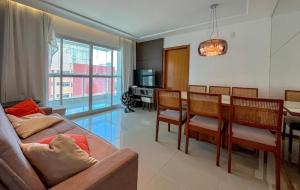 Una sala de estar con un sofá y un comedor. en Apartamento Centro, en Guarapari
