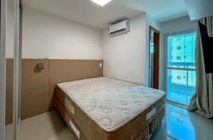 Habitación pequeña con cama en habitación con ventana en Apartamento Centro, en Guarapari