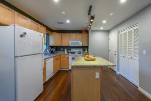 uma cozinha com uma geladeira branca e armários de madeira em Waterfront Condo, 25ft from riverwalk, Pool & HotTub em Portland