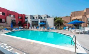 uma grande piscina com cadeiras e guarda-sóis em Waterfront Condo, 25ft from riverwalk, Pool & HotTub em Portland