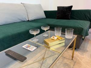 a living room with a couch and a glass table with wine glasses at Appartement 2 pièces - 550mètres du metro 13 in Saint-Denis