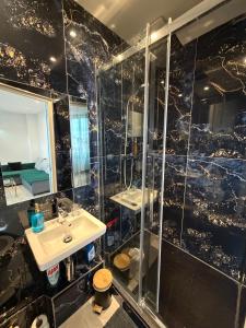 a bathroom with a sink and a shower with a mirror at Appartement 2 pièces - 550mètres du metro 13 in Saint-Denis