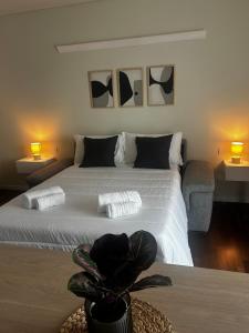 a bedroom with a bed with two lamps and a plant at Giax Tower-Spa, Pool, Parking in Milan