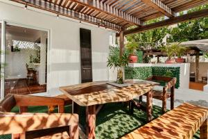 een patio met een houten tafel en stoelen bij Villa Lol Tun Breakfast and Beach Club Included in Isla Mujeres