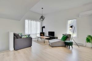 Assemblee Trio Portneuf - 3 Family Units - Spa & Nature في Pont-Rouge: غرفة معيشة مع أريكتين وطاولة
