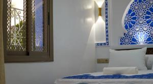 a bedroom with blue and white walls and a bed at Dar Ouadie the pearl stay in Chefchaouen