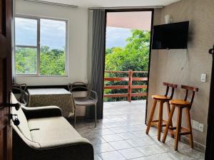 a room with a balcony with a table and chairs at Enseada Azul Home in Guarapari