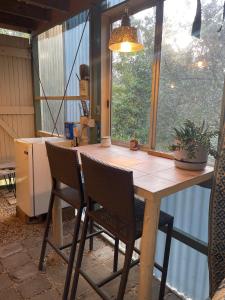 Una mesa y sillas en una cocina con ventana. en Getaway Spa Retreat with Watsu Pool Blue Mountains, en Hazelbrook