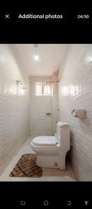 a white bathroom with a toilet and a window at 2bedroom house along waiyaki way in Nairobi +13 photos