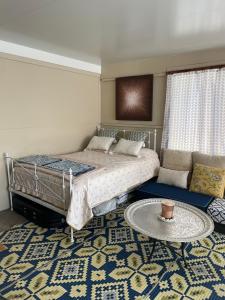 Un dormitorio con una cama y una mesa sobre una alfombra en Getaway Spa Retreat with Watsu Pool Blue Mountains, en Hazelbrook
