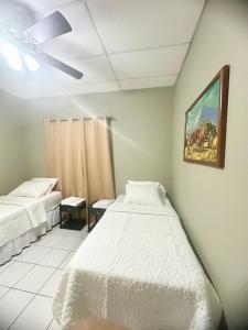 Habitación Doble Twin في ليون: غرفة بسريرين ولوحة على الحائط