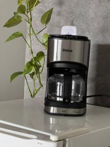 een koffiezetapparaat op een aanrecht met een plant bij Oásis 6 prática e bem localizada e minimalista in Brasilia