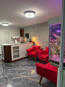 a waiting room with red chairs and an aquarium at Pousada Residencial A Dantas in Búzios