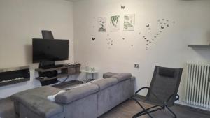 sala de estar con sofá, TV y silla en GS Valtellina, en Morbegno