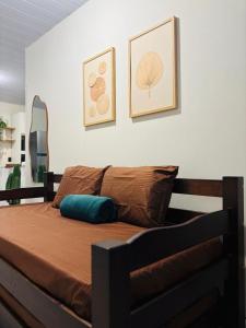 a bed in a bedroom with two pictures on the wall at Casa aconchegante pertinho da Praia Central in Itapema