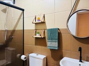 a bathroom with a toilet and a mirror and a sink at Casa aconchegante pertinho da Praia Central in Itapema