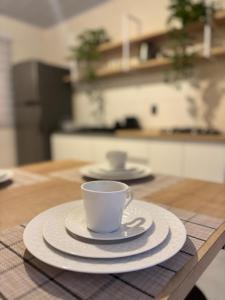 a coffee cup and saucer on a table in a kitchen at Casa aconchegante pertinho da Praia Central in Itapema +5 photos