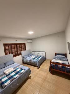 two beds and a couch in a room at Pousada São Gabriel - M&M in São Gabriel