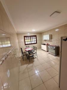 a large kitchen with a table and chairs in it at Pousada São Gabriel - M&M in São Gabriel
