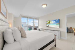 une chambre blanche avec un lit et une grande fenêtre dans l'établissement Luxury Waterfront W Hotel Condo Brickell Skyline Views, à Miami
