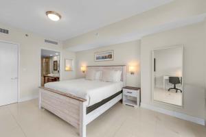 une chambre blanche avec un lit et un miroir dans l'établissement Luxury Waterfront W Hotel Condo Brickell Skyline Views, à Miami 18 autres photos