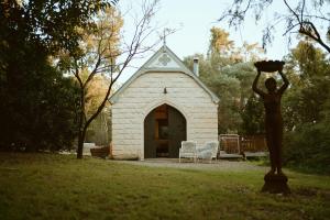 a statue of a person in front of a small chapel at Stone Guest House Ebenezer in Ebenezer