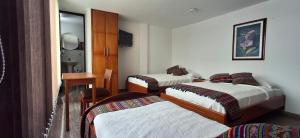1 dormitorio con 3 camas y espejo en Hotel San Marcos Las Lajas, en Ipiales