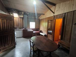 a kitchen with a wooden table and chairs in a room at Sitio alto valinhos in Itamonte