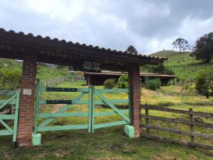 a gate in a field with a fence at Sitio alto valinhos in Itamonte +2 photos