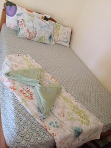 a bed with a blanket and pillows on it at Calitang Pearl Cottage in Nacpan +23 photos