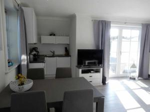 a kitchen and living room with a table and chairs at Refugium 54° Timmendorfer Strand in Timmendorfer Strand