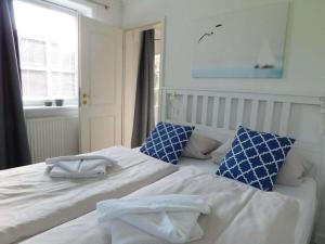 two beds in a bedroom with blue and white pillows at Refugium 54° Timmendorfer Strand in Timmendorfer Strand