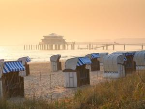 a row of chairs on the beach near the ocean at Refugium 54° Timmendorfer Strand in Timmendorfer Strand +3 photos
