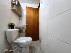 um banheiro com vaso sanitário e pia em Rincon Urbano Tunja Alojamiento em Tunja
