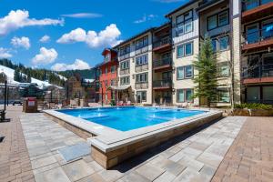 a swimming pool in the middle of a courtyard with buildings at Ski-In / Ski-Out 1 Bedroom Condo base of WP Resort in Winter Park