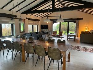 a living room with a large wooden table and chairs at Five-Bedroom Holiday Home in Somme-Leuze in Somme-Leuze